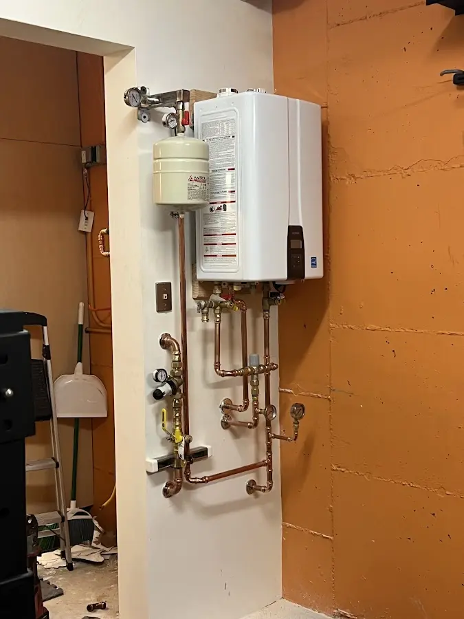 Plumbing technician inspecting water heater connections in Wilmette
